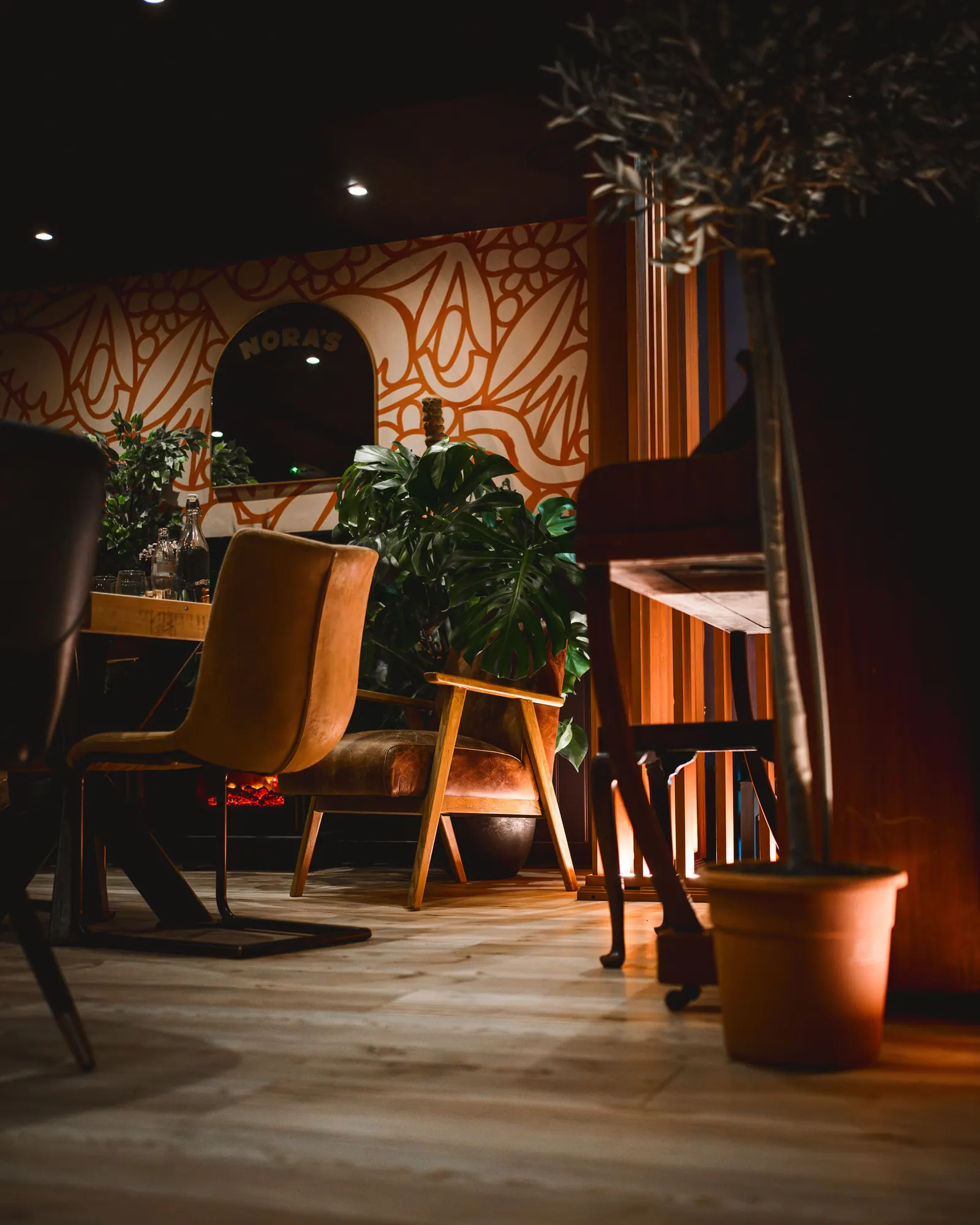 The dining room at NORA'S with a hand-painted mural and plants